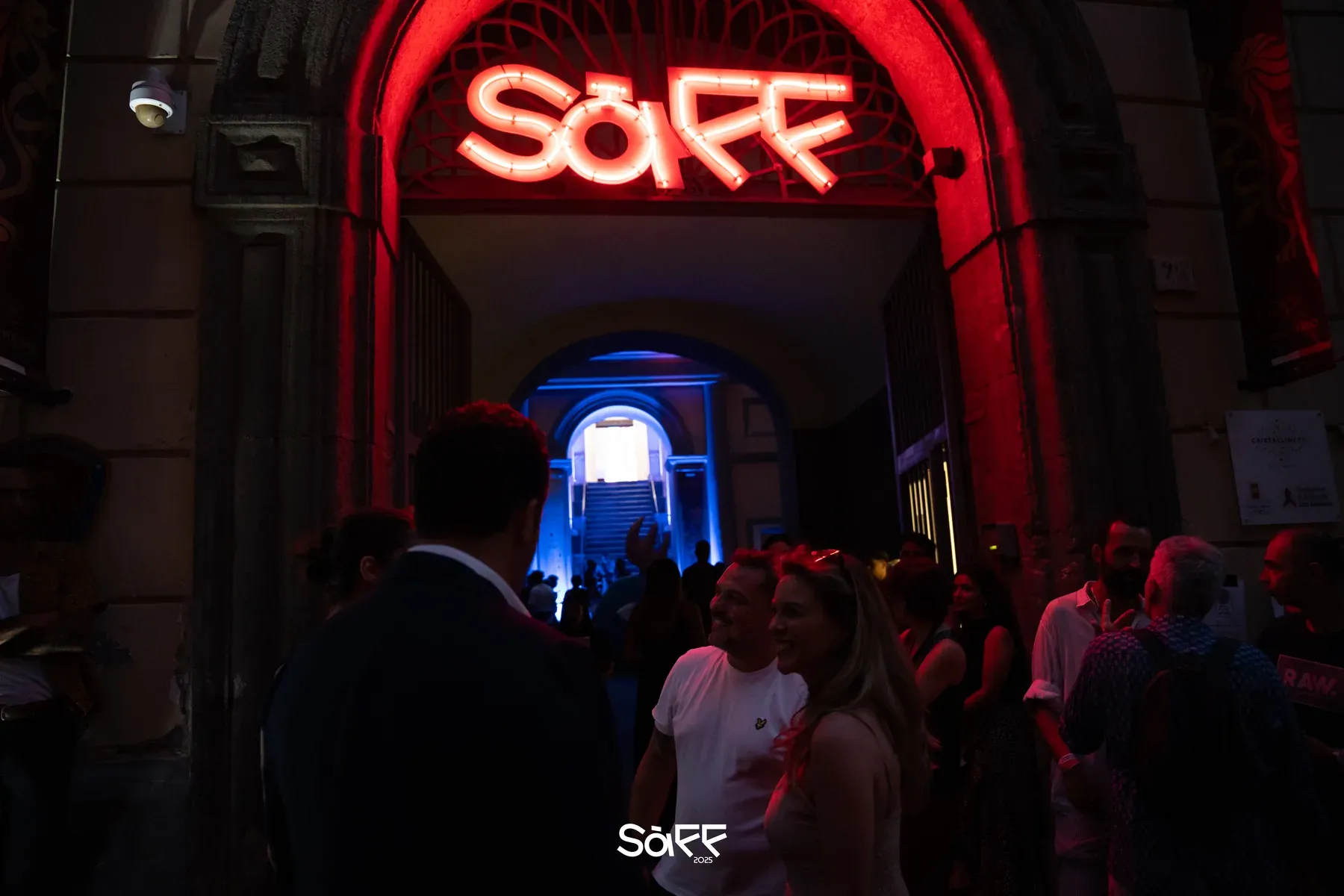The SàFF neon sign above the entrance arch, with the audience walking in