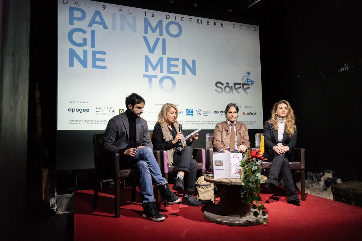 Quattro relatori seduti sul palco sotto uno schermo con la scritta Pagine in Movimento, dal 9 al 13 dicembre 2025, con una stella di Natale sul tavolino